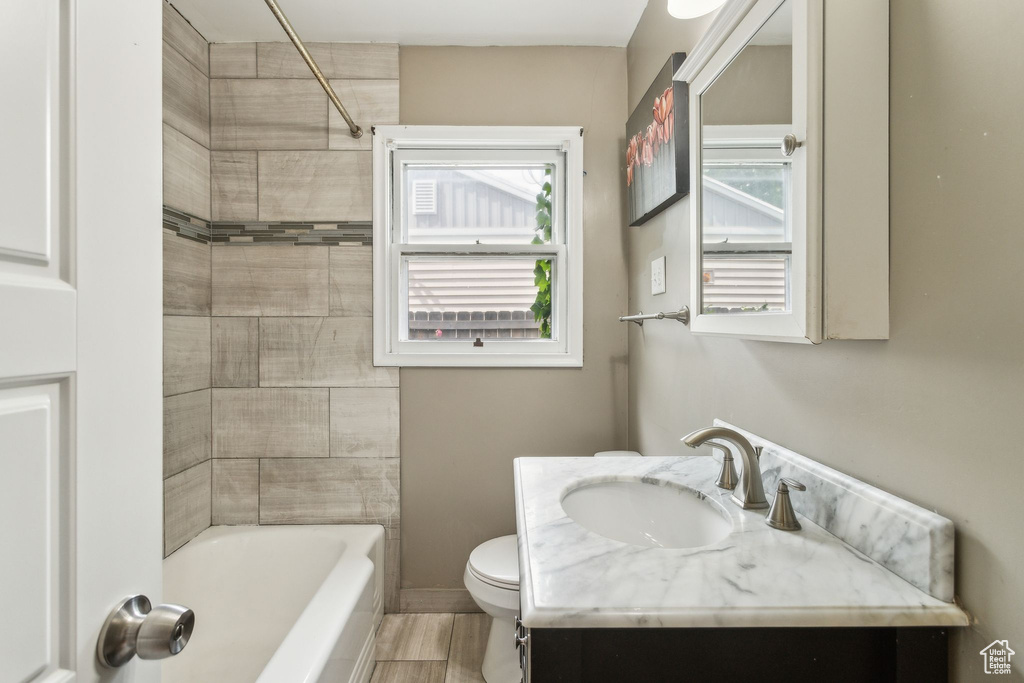 Full bathroom with toilet, vanity, shower / tub combination, and wood finished floors