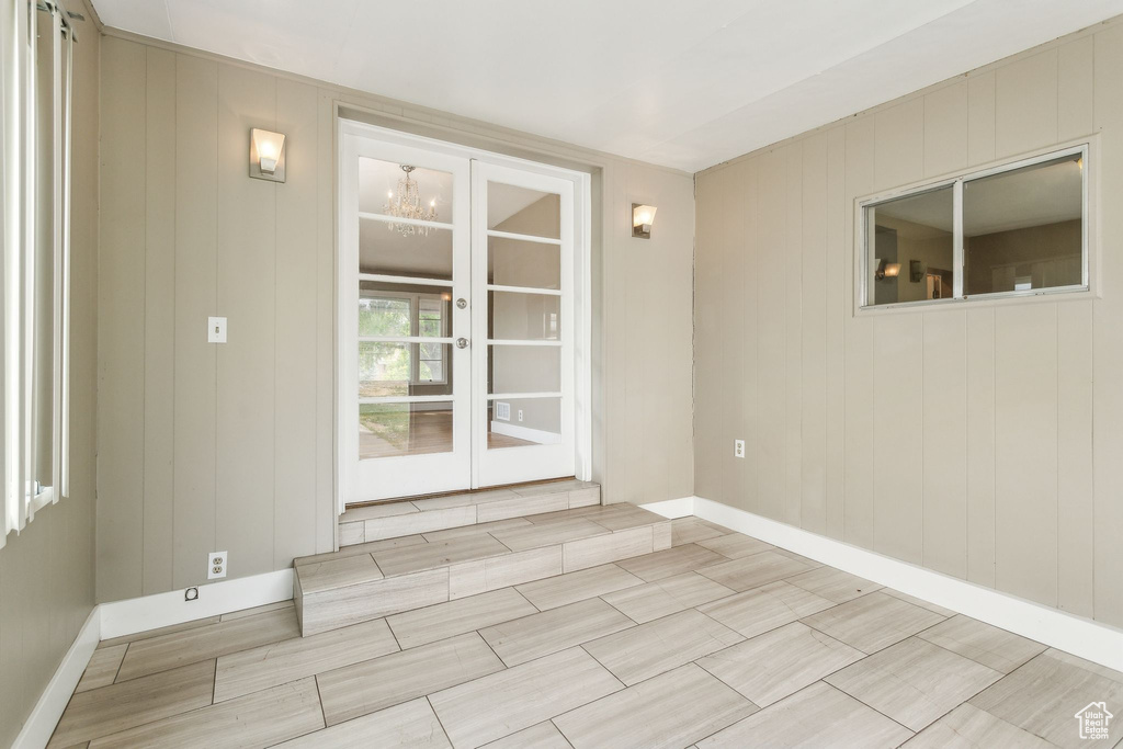 Empty room featuring a chandelier and baseboards