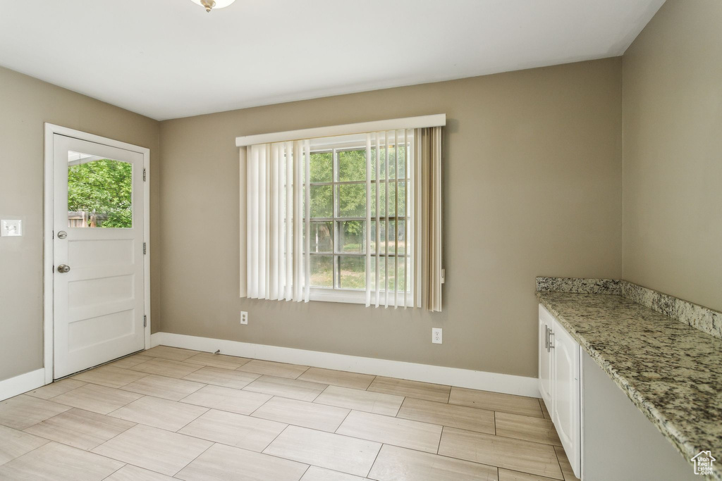 Unfurnished dining area featuring baseboards