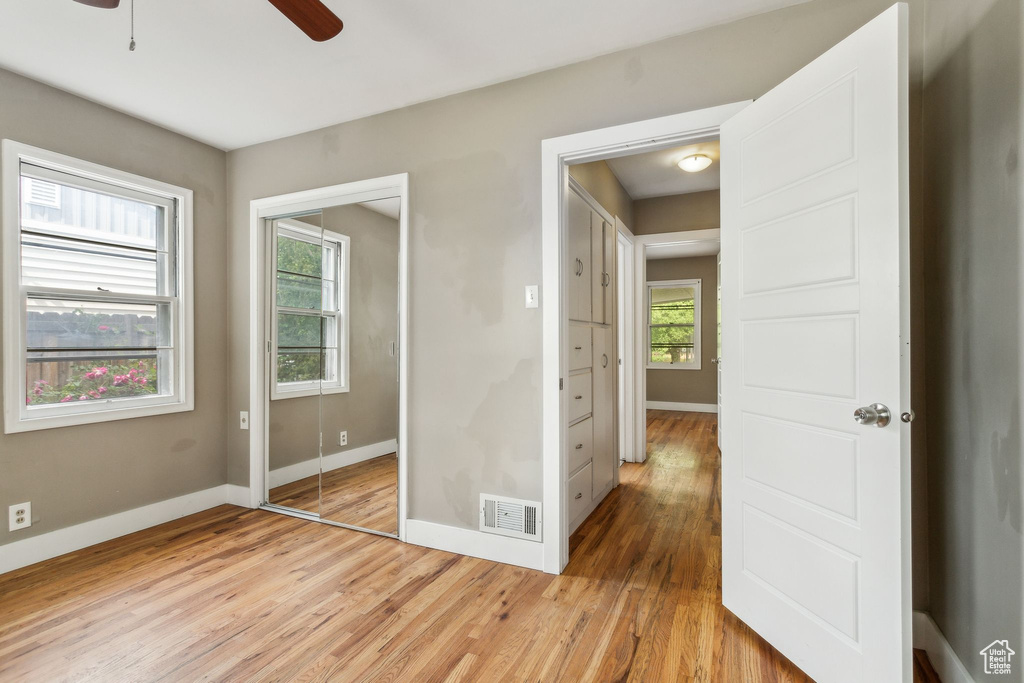 Unfurnished bedroom with baseboards, light wood-style flooring, a closet, and ceiling fan