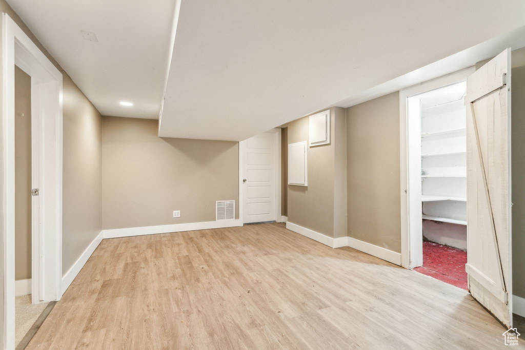 Finished below grade area featuring light wood finished floors, baseboards, and recessed lighting