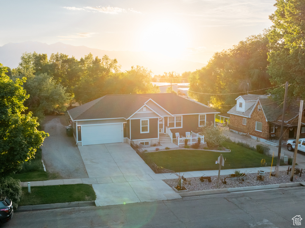 View of front of home with an attached garage, a front lawn, and concrete driveway