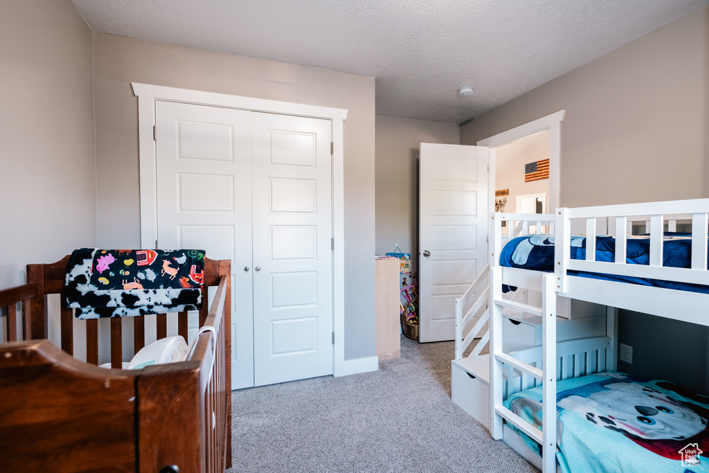 Carpeted bedroom featuring a closet and baseboards
