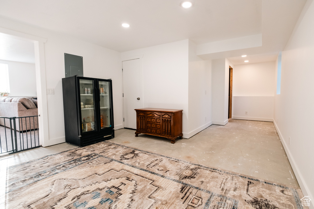 Unfurnished room with concrete floors, recessed lighting, baseboards, and electric panel