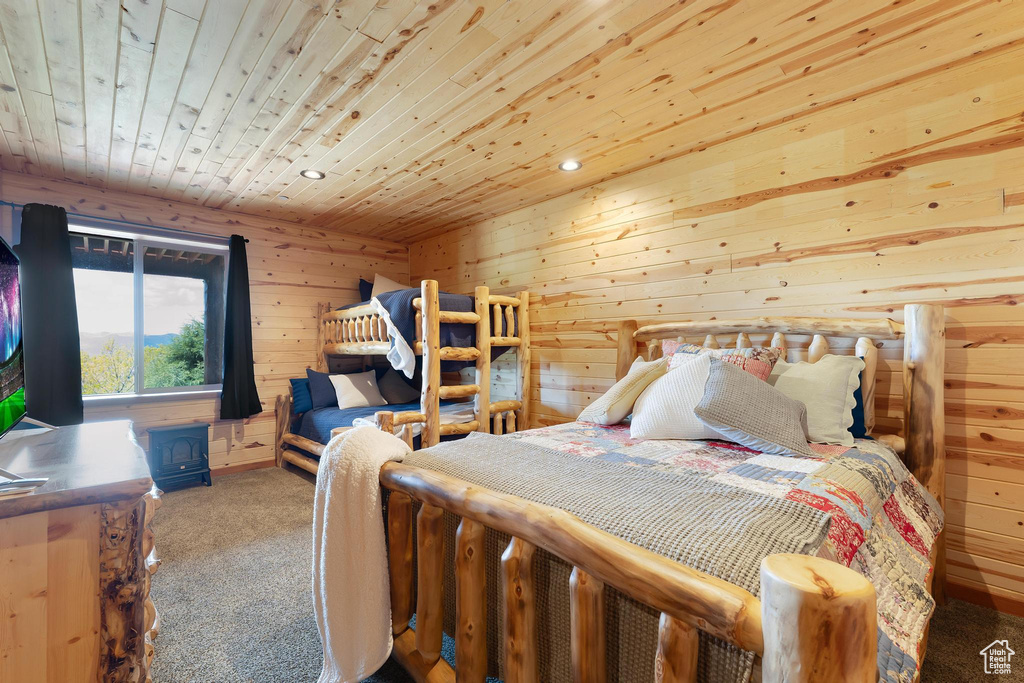Carpeted bedroom featuring wooden ceiling, recessed lighting, and wooden walls