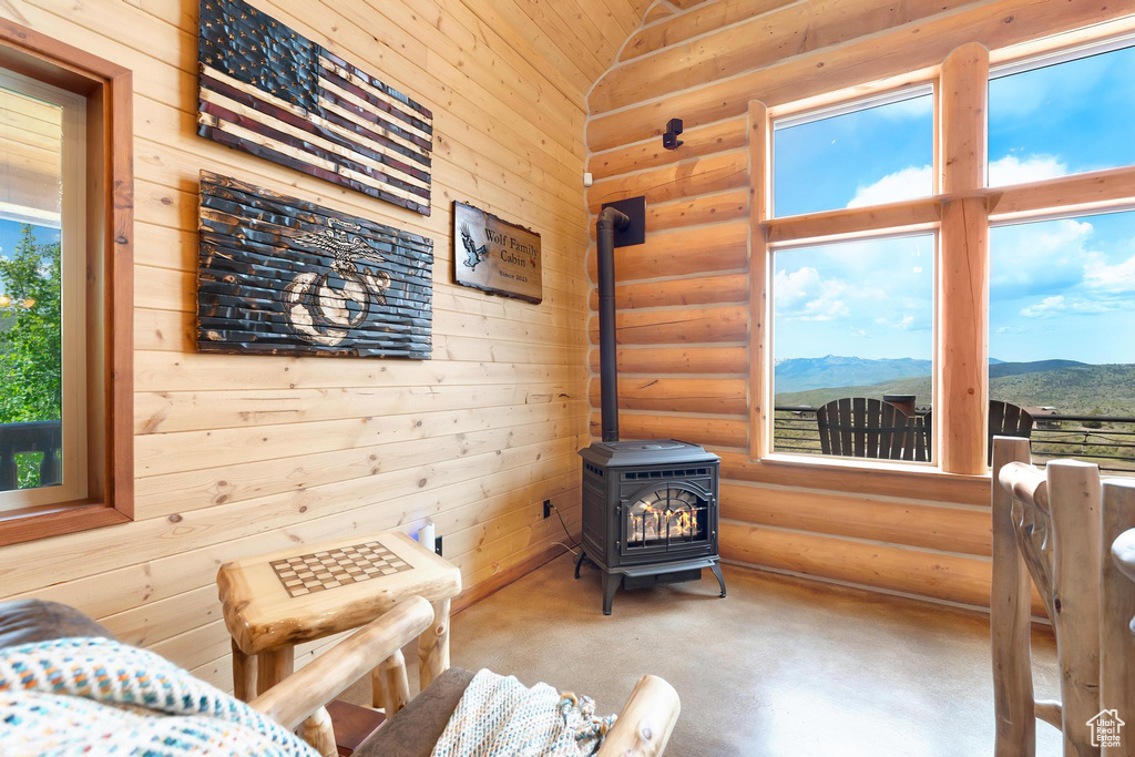 Sitting room with a wood stove, a mountain view, and rustic walls