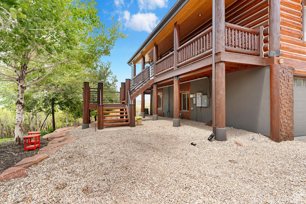 View of property exterior featuring stairway and a wooden deck