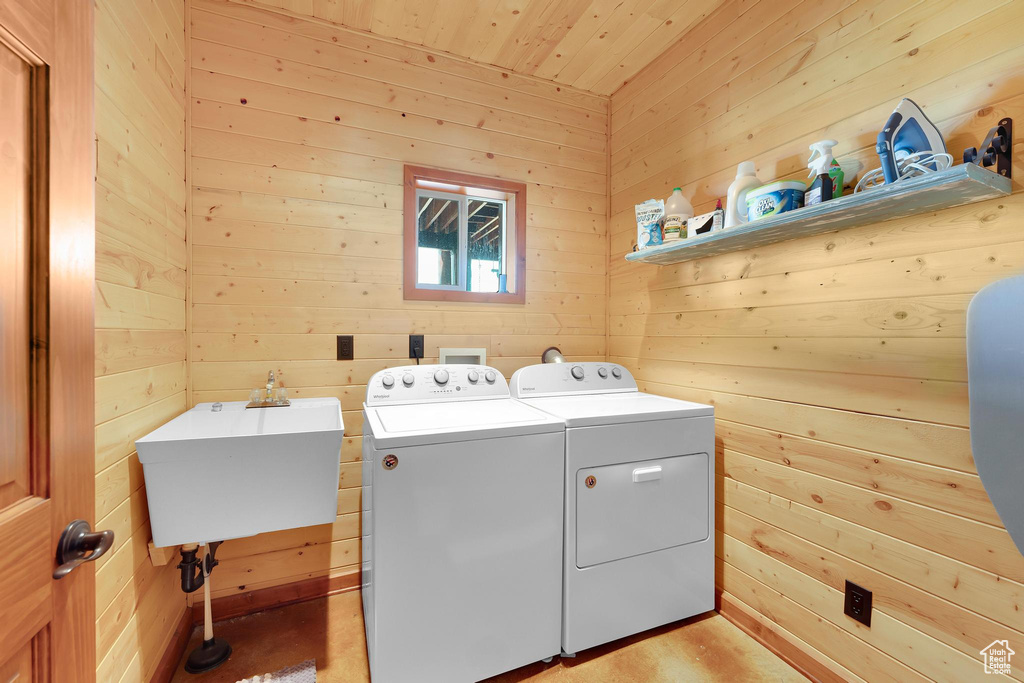 Washroom with washing machine and clothes dryer, wooden walls, and wooden ceiling