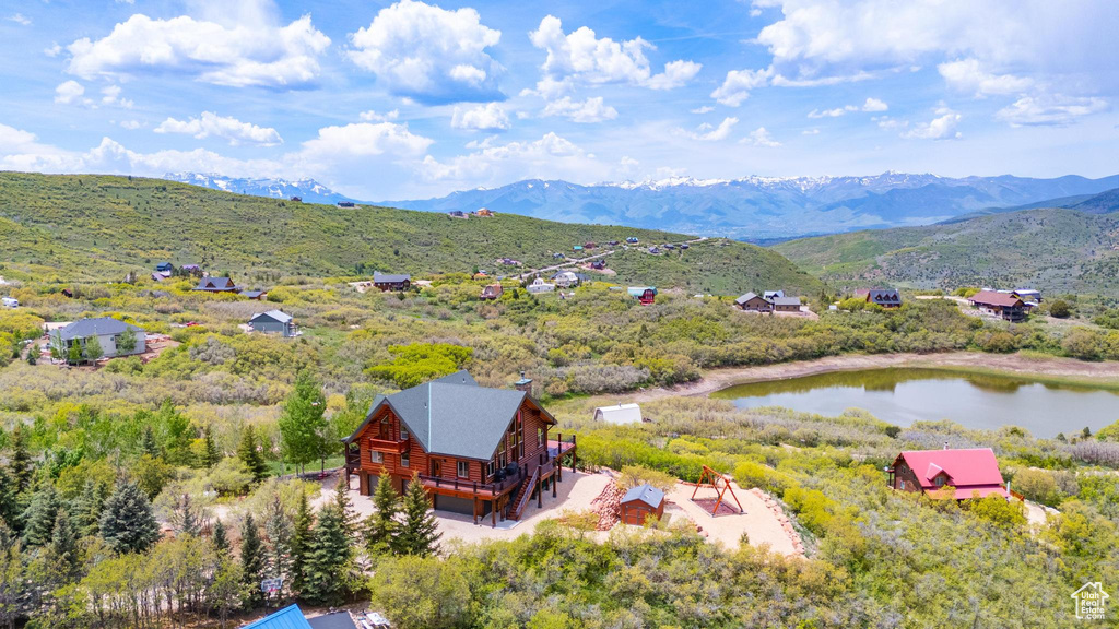 View of subject property with a water and mountain view
