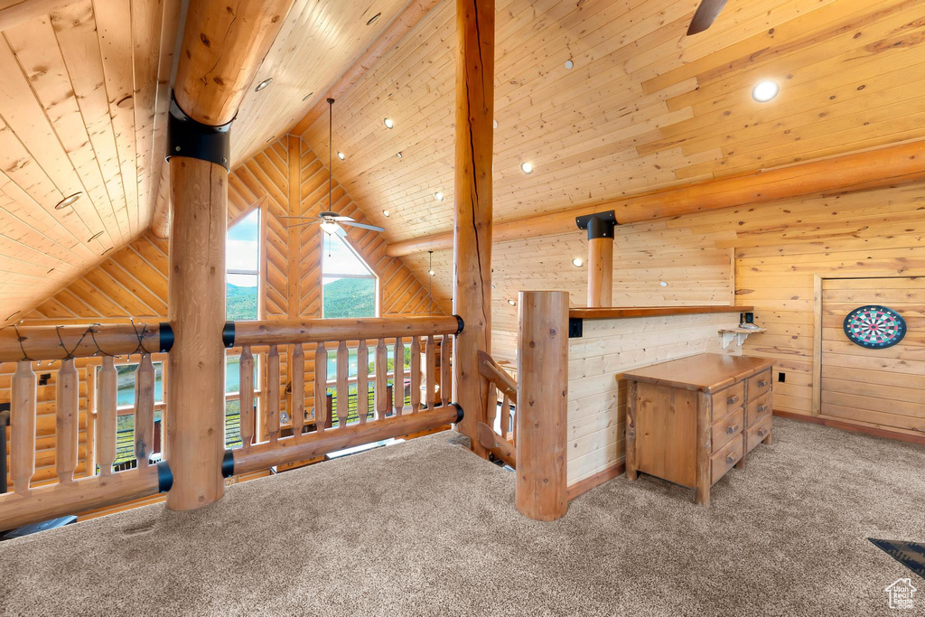 Additional living space featuring carpet flooring, rustic walls, wood ceiling, high vaulted ceiling, and ceiling fan