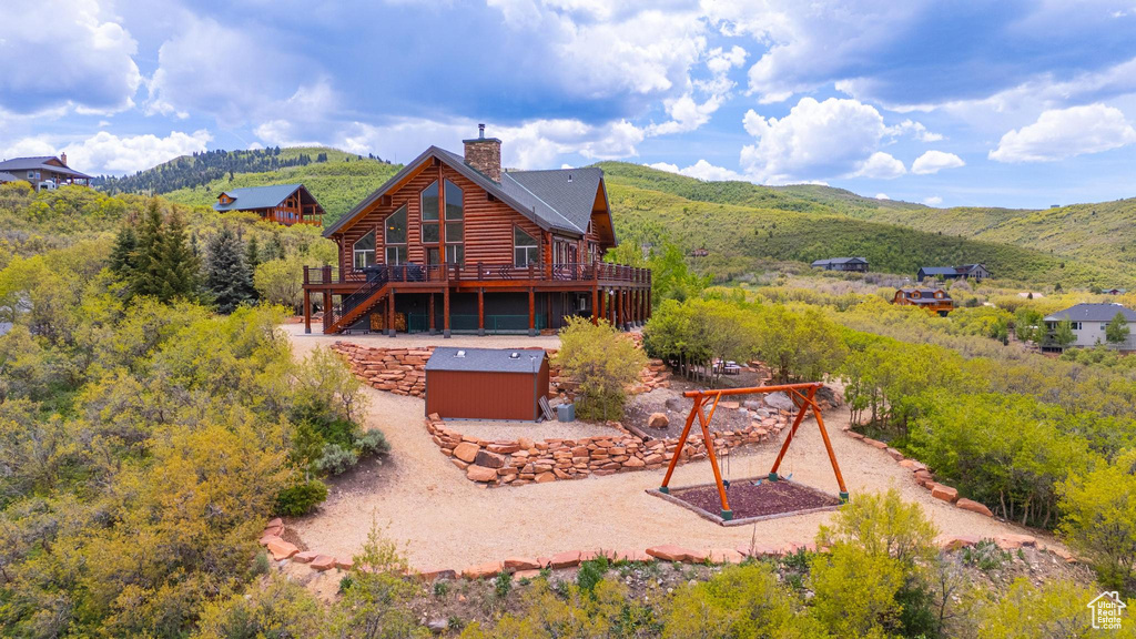 Rear view of property featuring a deck with mountain view and a chimney