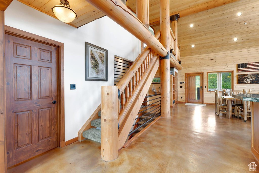 Foyer with wood ceiling, stairway, recessed lighting, finished concrete floors, and baseboards