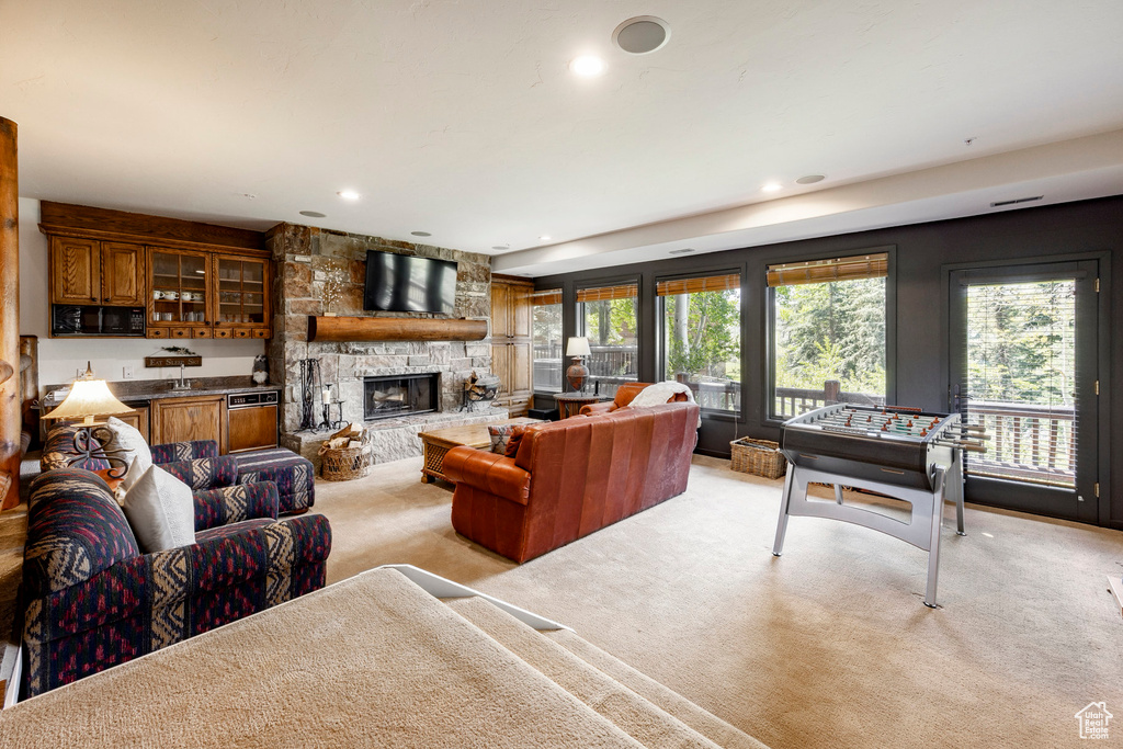 Living area featuring light carpet, a fireplace, and recessed lighting