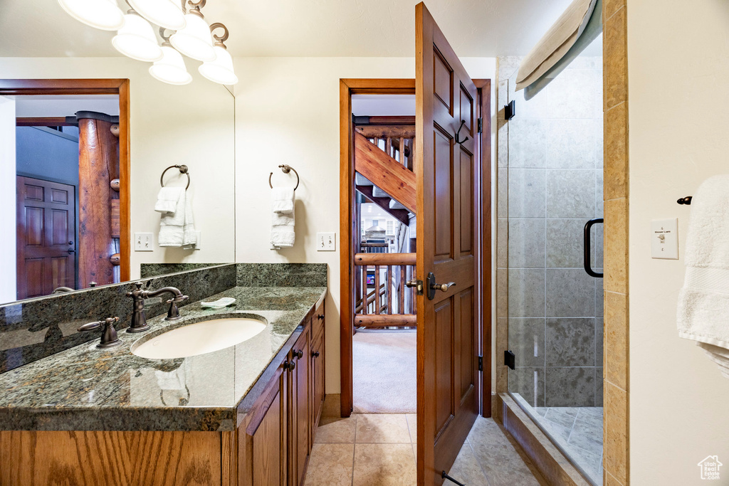 Bathroom featuring vanity, tile patterned floors, and a shower stall