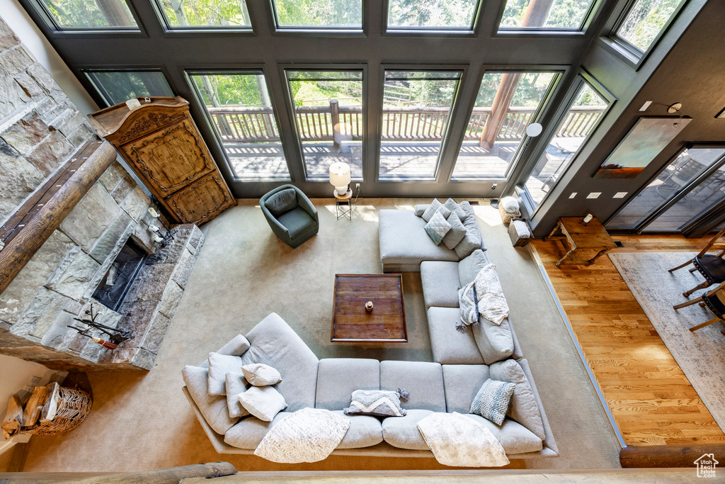 Living area with a high ceiling, wood finished floors, and a premium fireplace
