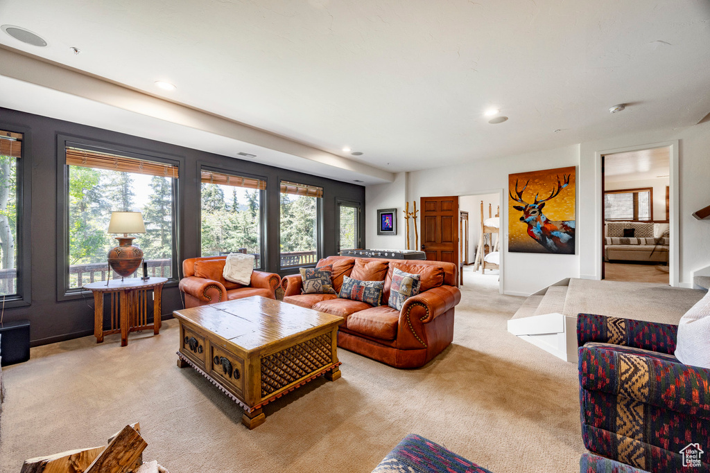 Living area with light carpet and recessed lighting