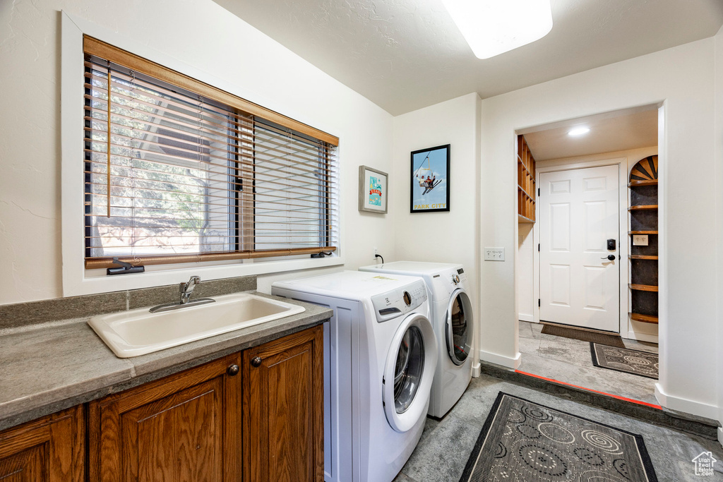 Laundry room with washer and clothes dryer, cabinet space, and baseboards