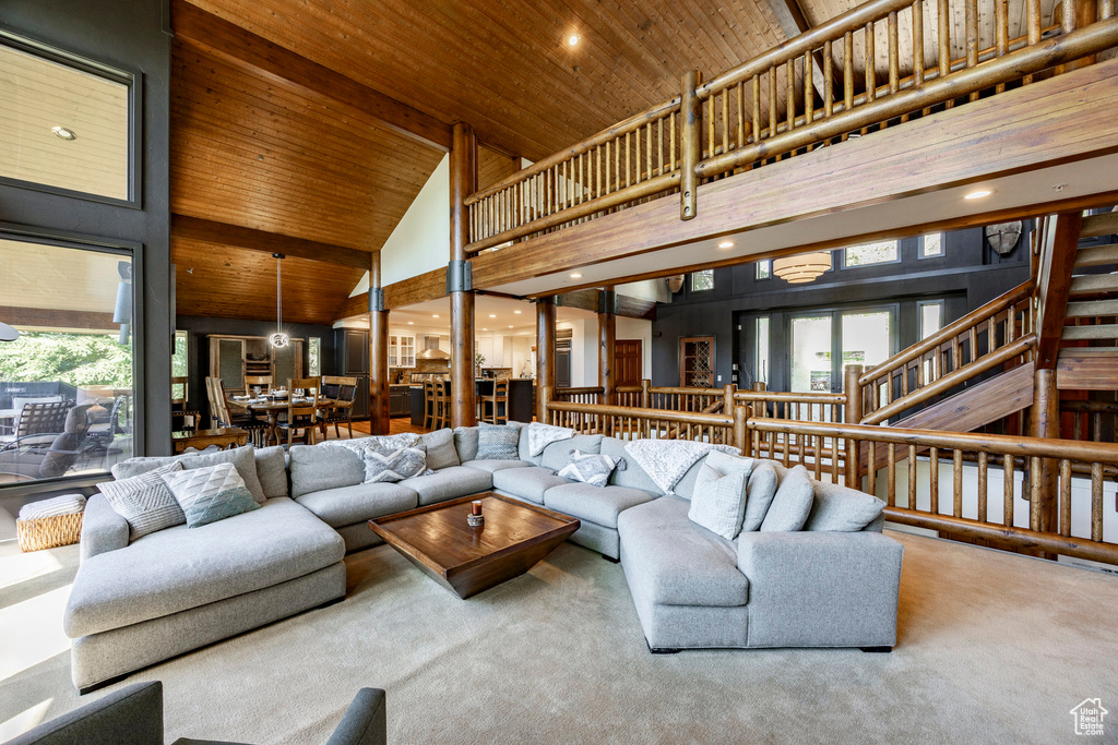 Carpeted living area with high vaulted ceiling, wooden ceiling, plenty of natural light, and recessed lighting