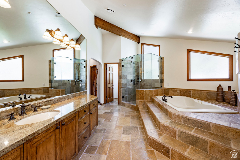 Full bath with stone tile floors, a shower stall, a garden tub, vanity, and recessed lighting