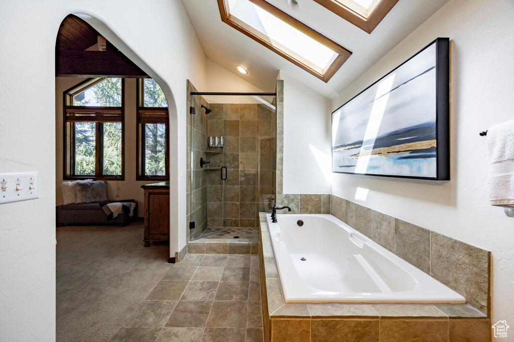 Ensuite bathroom with a garden tub, a stall shower, and vaulted ceiling