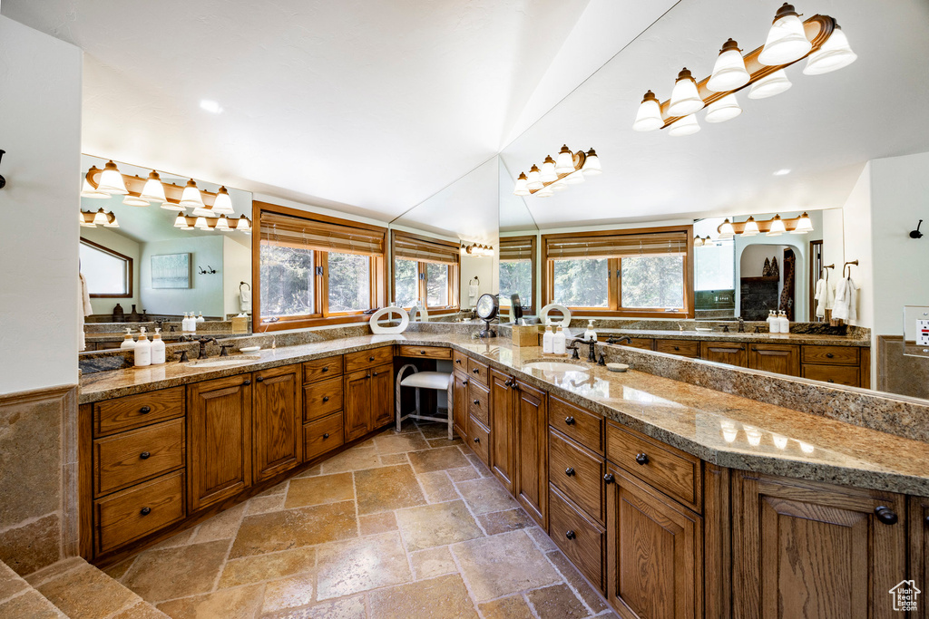 Full bathroom featuring stone tile flooring and vanity