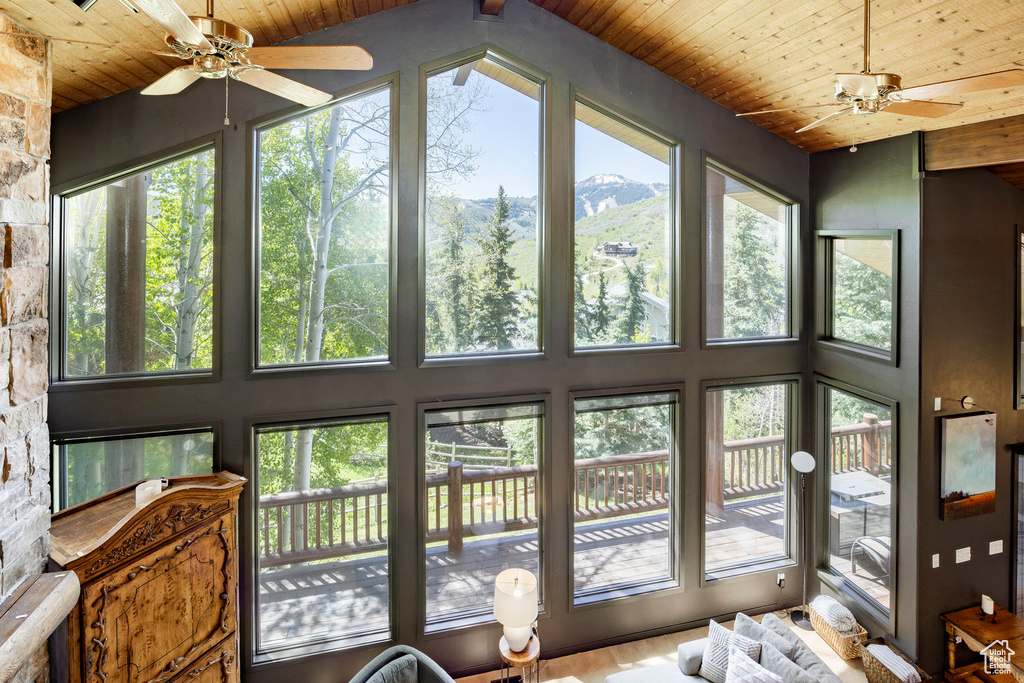 Sunroom / solarium featuring wooden ceiling and a mountain view