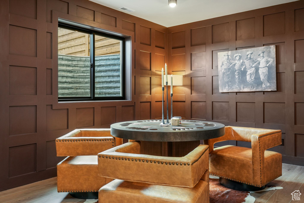 Sitting room with a decorative wall and light wood-style flooring