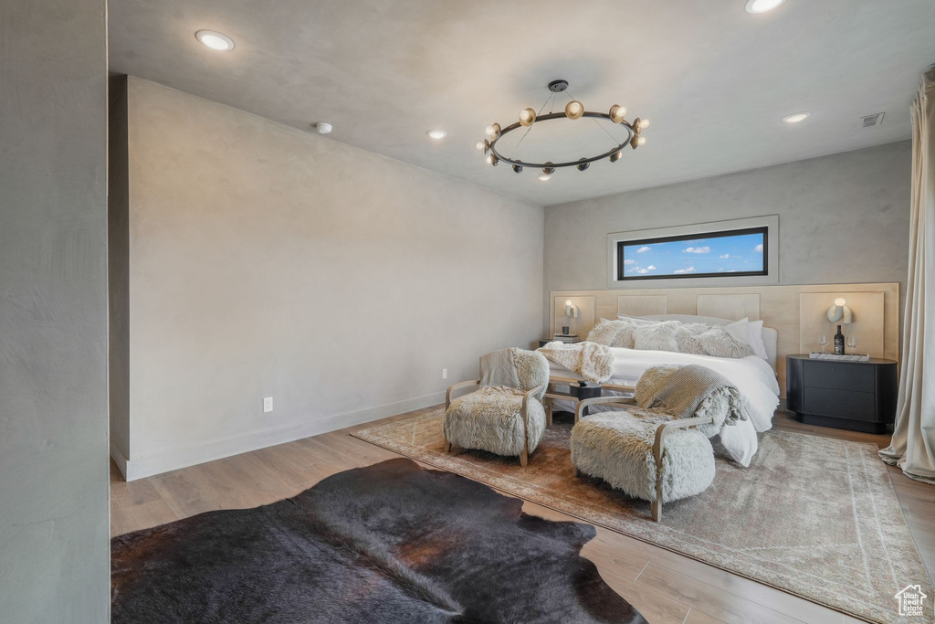 Bedroom featuring wood finished floors, recessed lighting, and a chandelier