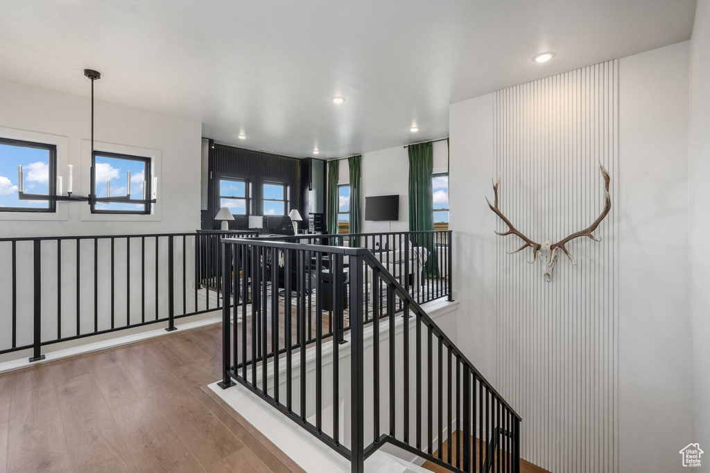 Hallway featuring an upstairs landing, wood finished floors, and recessed lighting