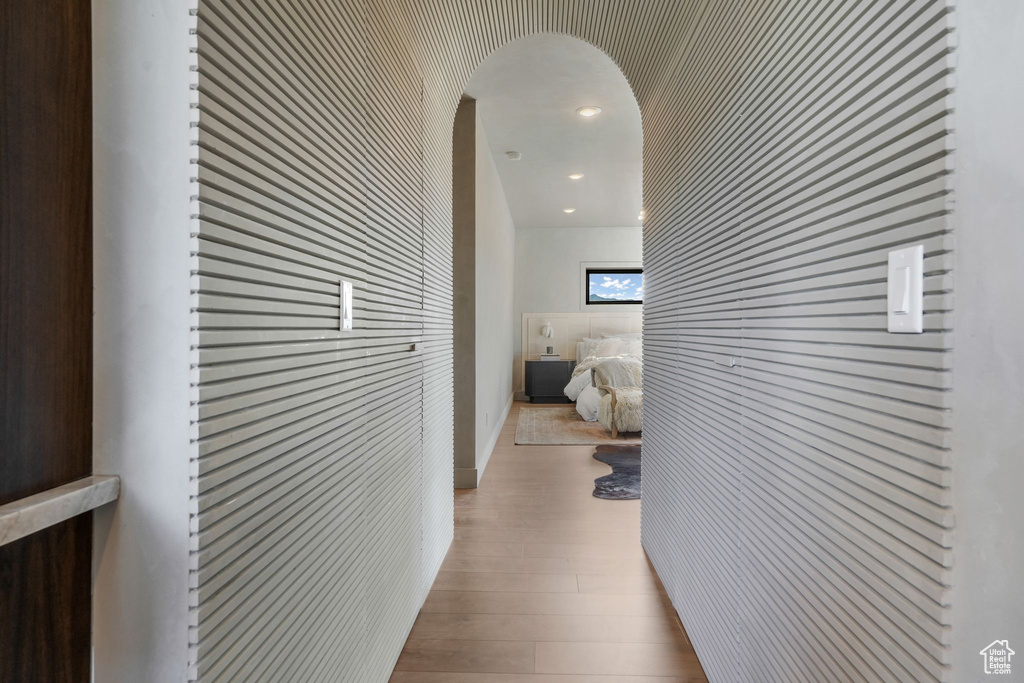 Corridor featuring wood finished floors and arched walkways