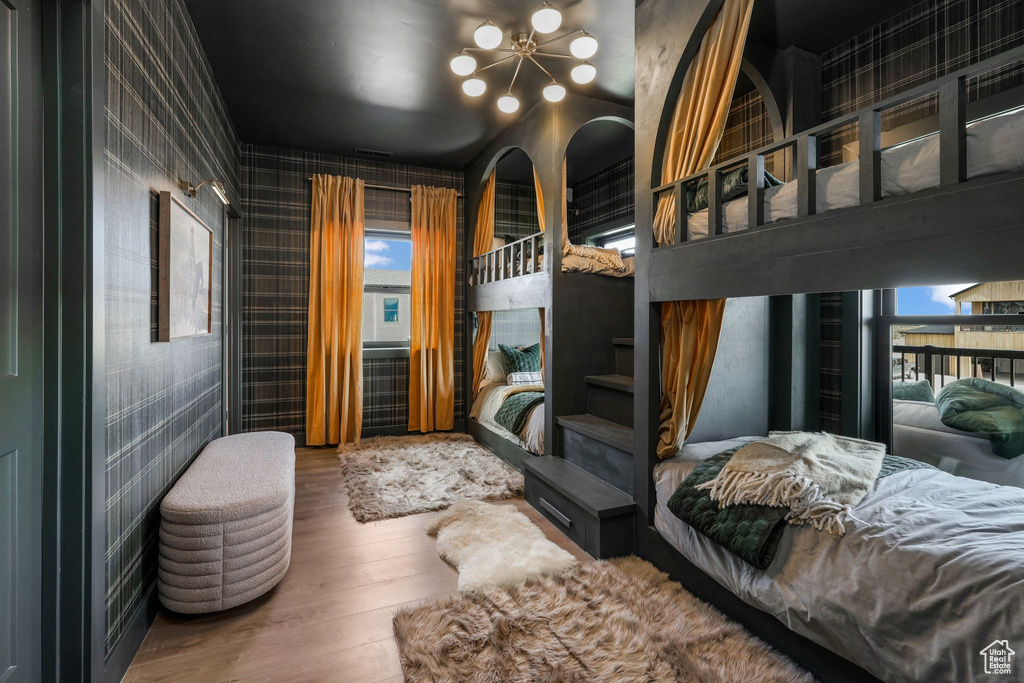 Bedroom featuring wood finished floors and a chandelier