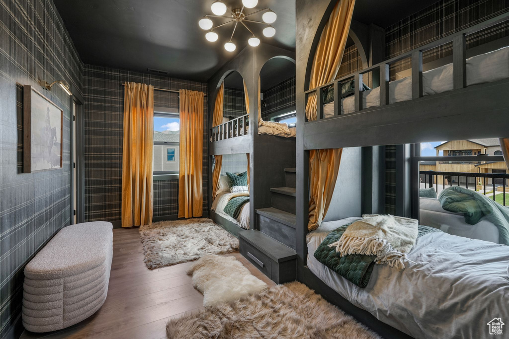 Bedroom with wood finished floors and a chandelier