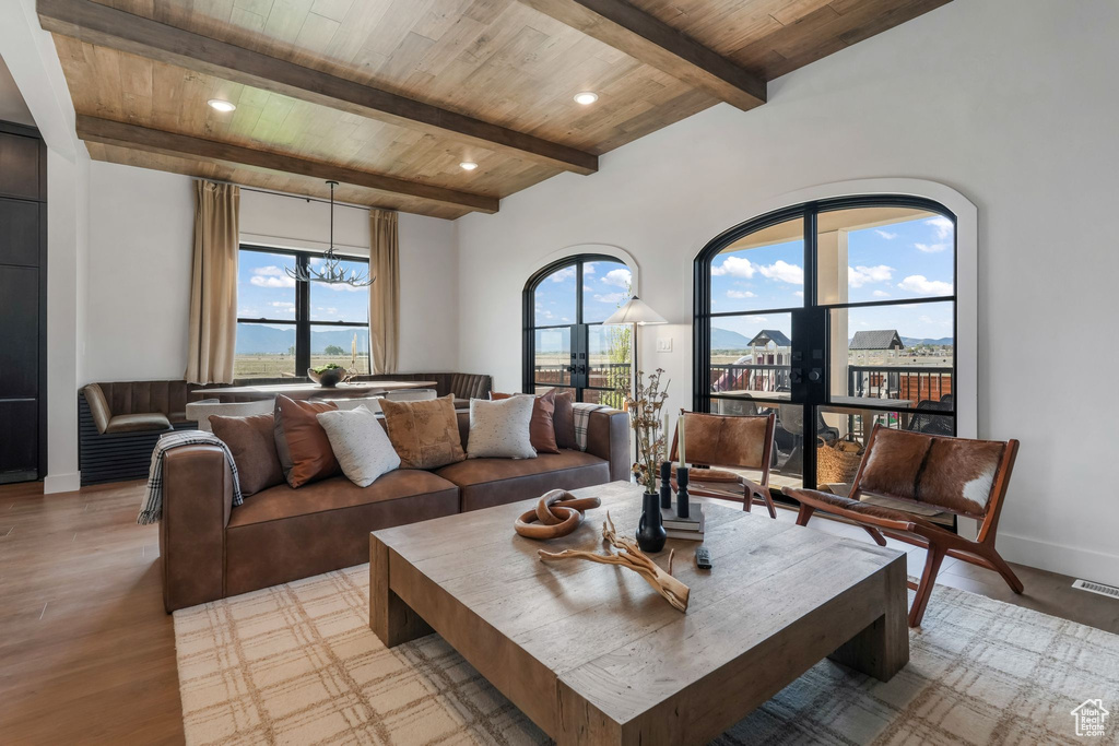 Living area with wooden ceiling with exposed beams, a chandelier, light wood-style flooring, baseboards, and recessed lighting