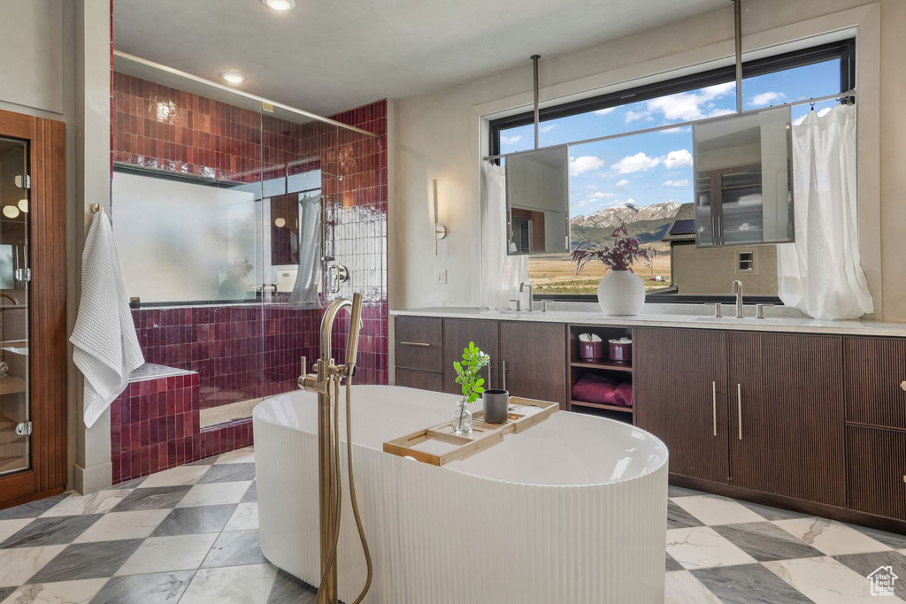 Full bath featuring vanity, a freestanding tub, a shower with curtain, tile patterned floors, and recessed lighting