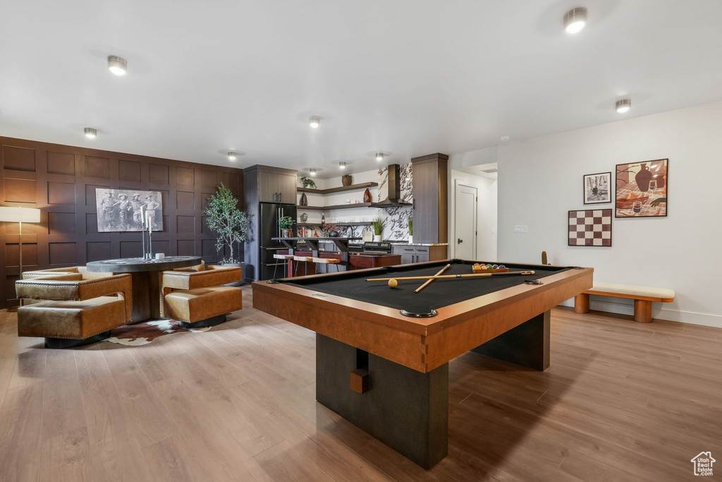 Recreation room with light wood finished floors, baseboards, and billiards