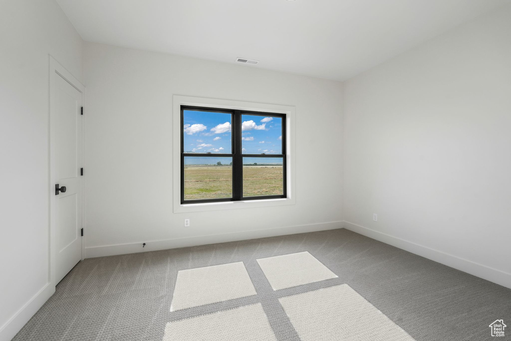 Spare room featuring carpet and baseboards