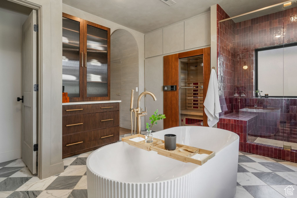 Full bath featuring a soaking tub, a sink, and wine cooler