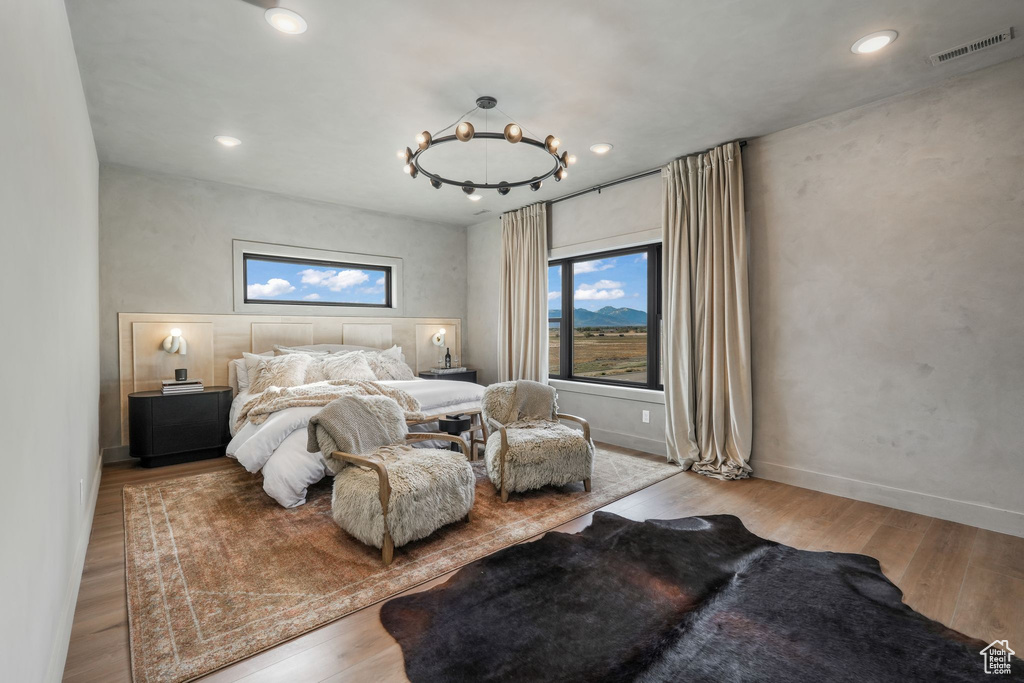 Bedroom featuring wood finished floors, a chandelier, recessed lighting, and baseboards