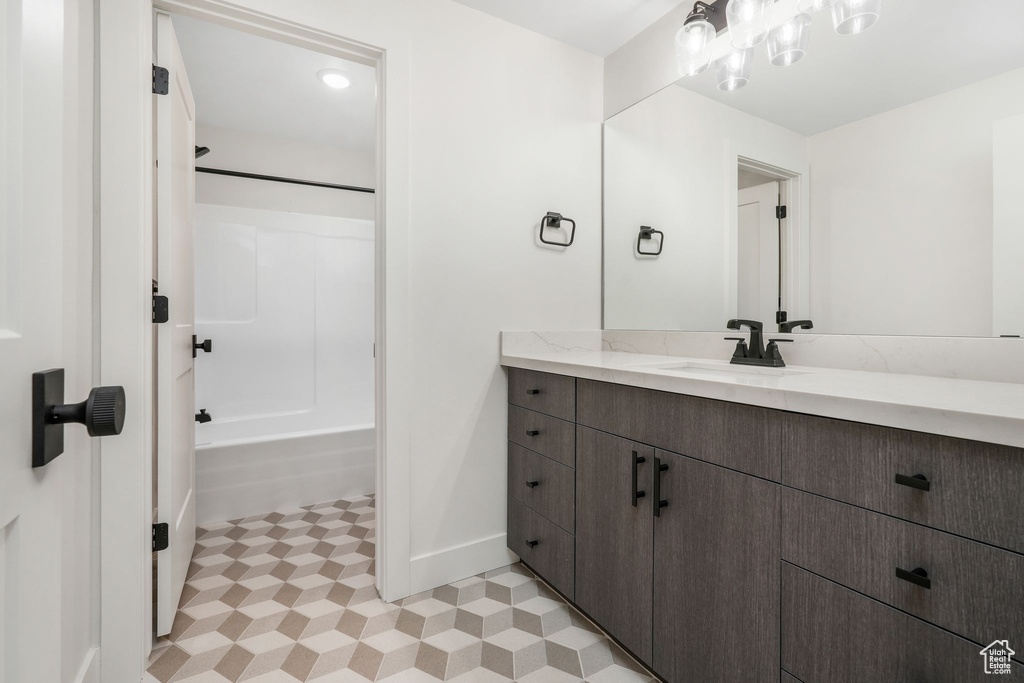 Bathroom with vanity, baseboards,  shower combination, and tile patterned floors