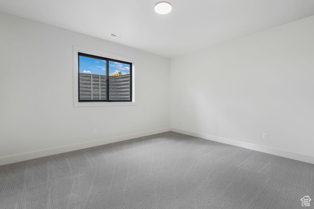 Carpeted spare room with baseboards