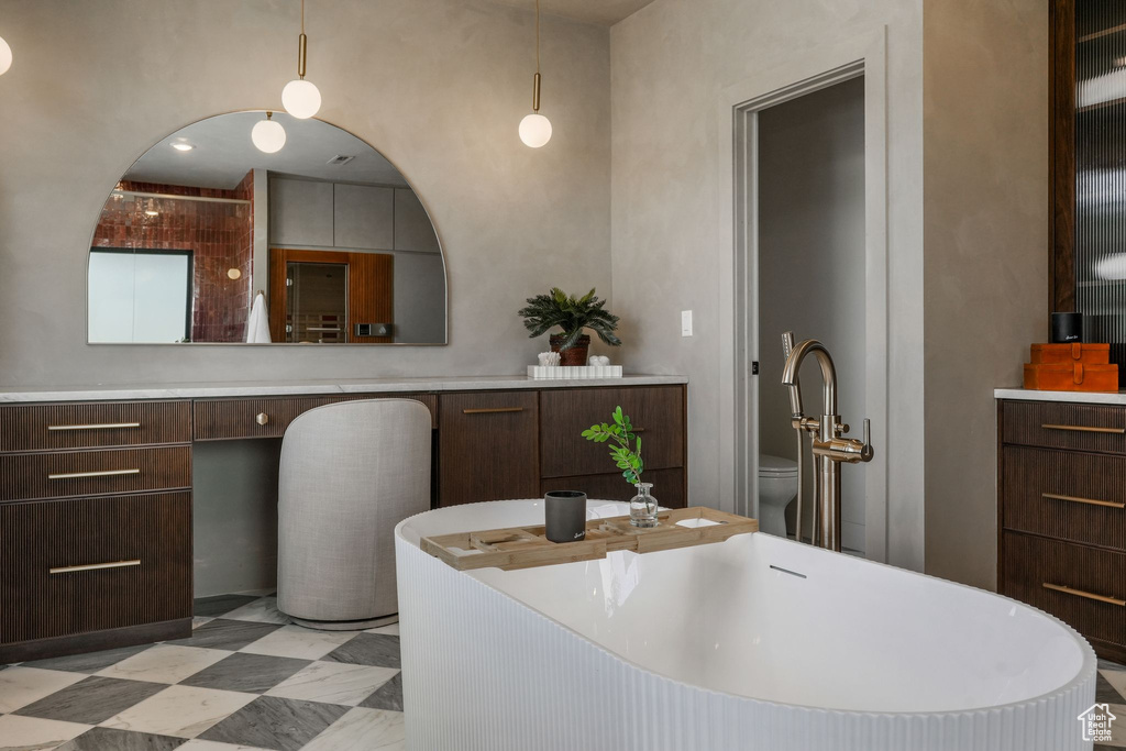 Bathroom featuring a freestanding bath, toilet, and a sink