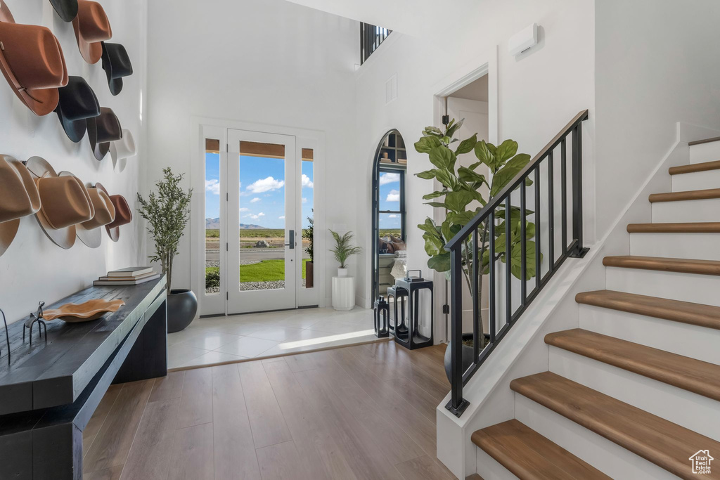 Entrance foyer featuring wood finished floors, stairway, and a towering ceiling