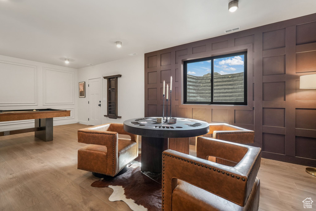 Dining space with a decorative wall and light wood-type flooring