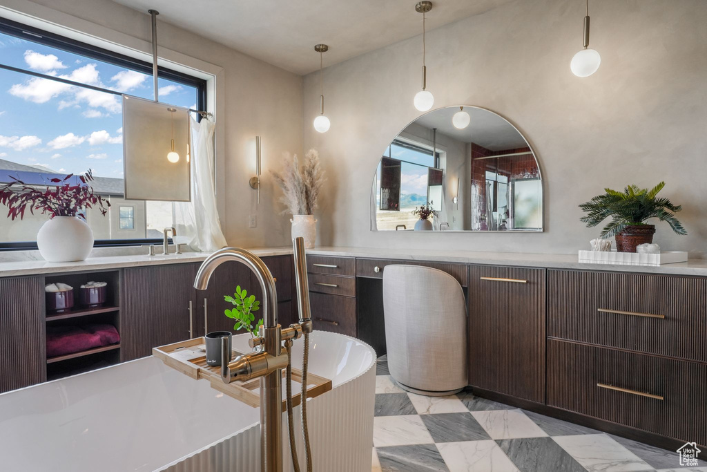Bathroom with vanity, a bathtub, and marble finish flooring
