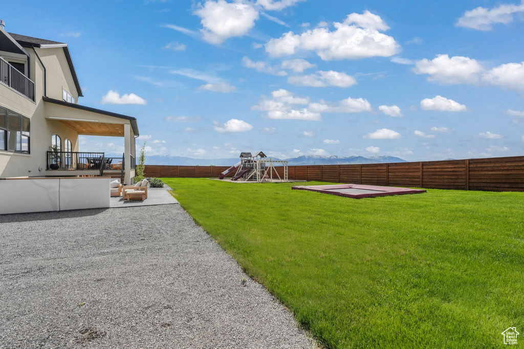 View of yard with a playground and a patio