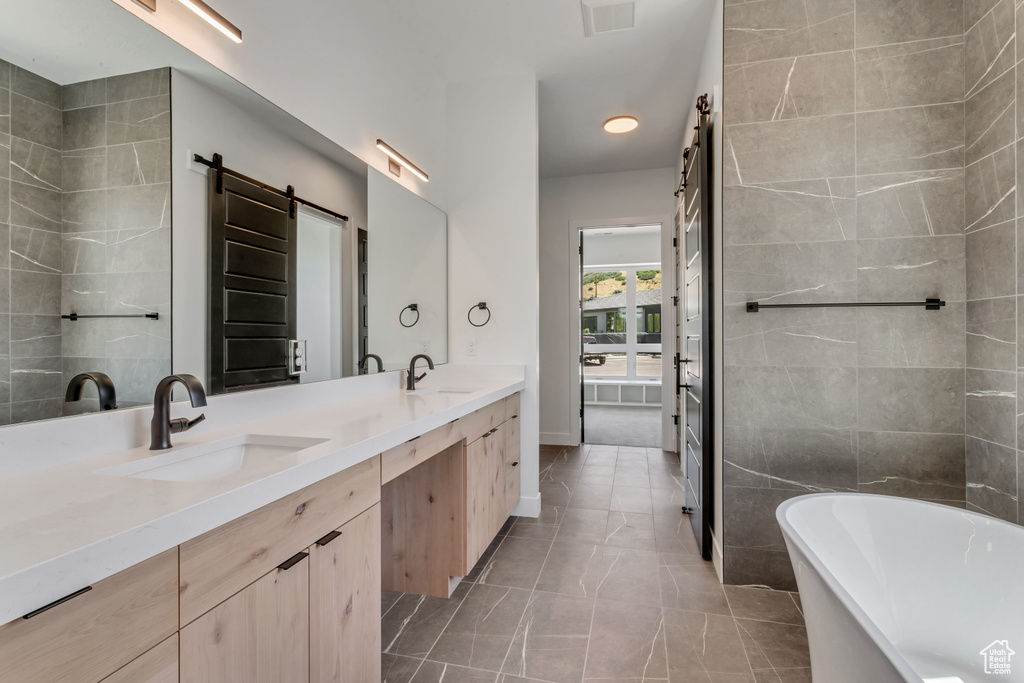 Bathroom featuring a soaking tub, double vanity, and baseboards