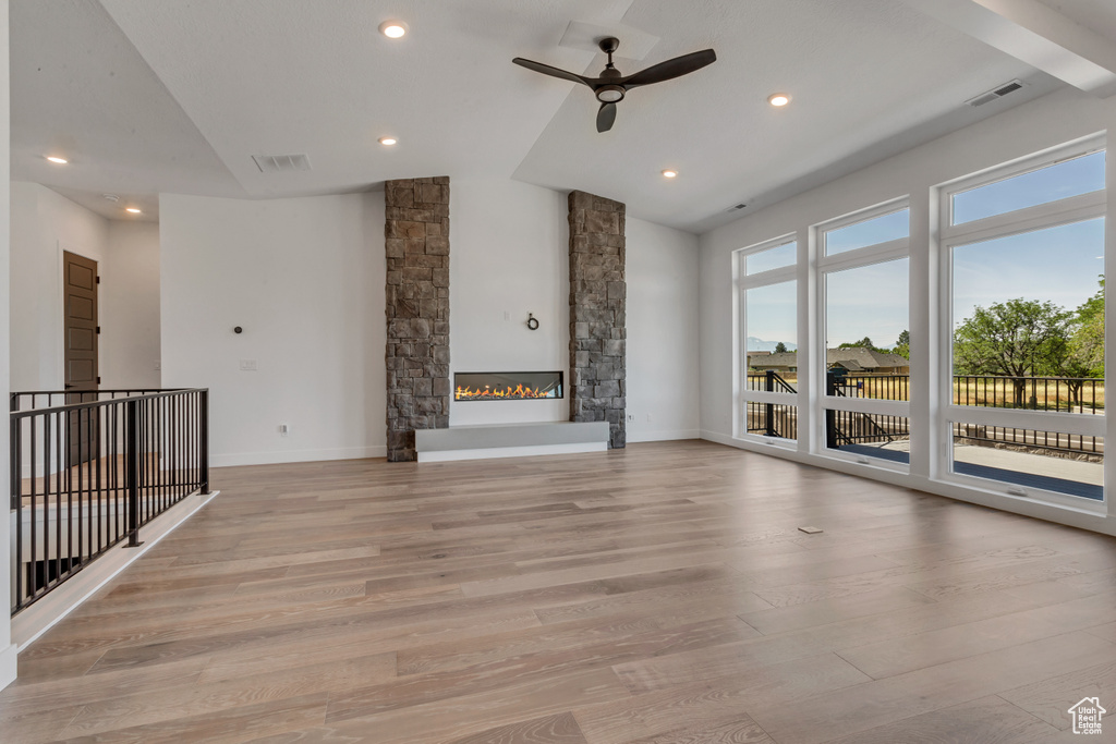 Unfurnished living room with ceiling fan, lofted ceiling, light wood finished floors, recessed lighting, and a fireplace