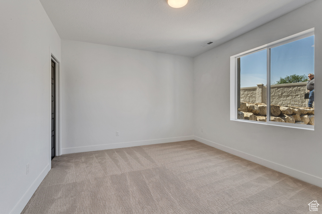 Carpeted spare room with baseboards