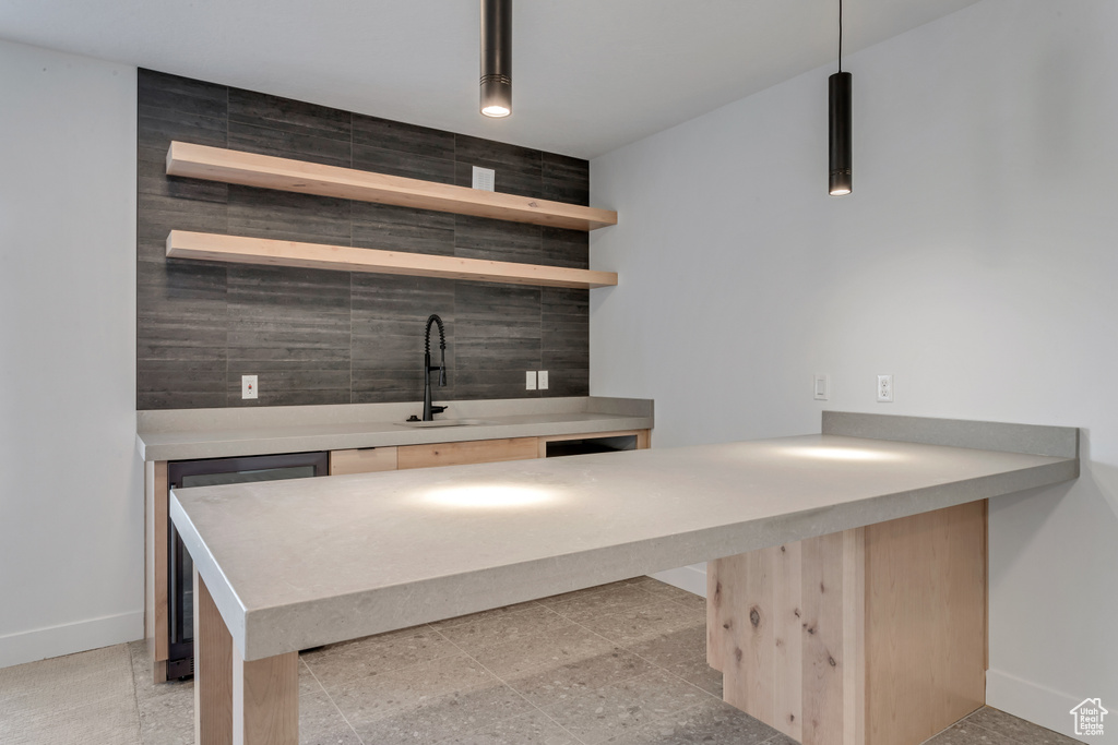 Bar with a sink, baseboards, decorative light fixtures, and wine cooler