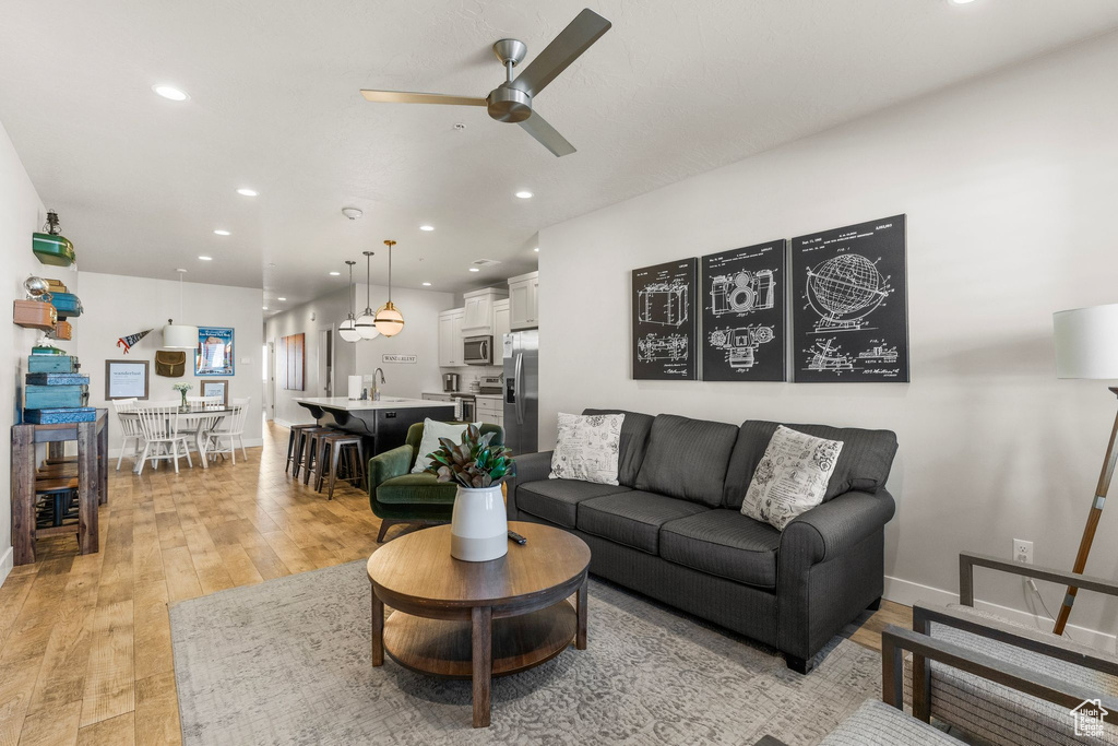 Living area featuring ceiling fan, light wood-style floors, recessed lighting, and baseboards
